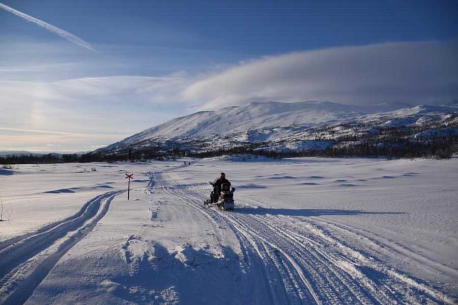 Mensen op een sneeuwscooter in de bergen