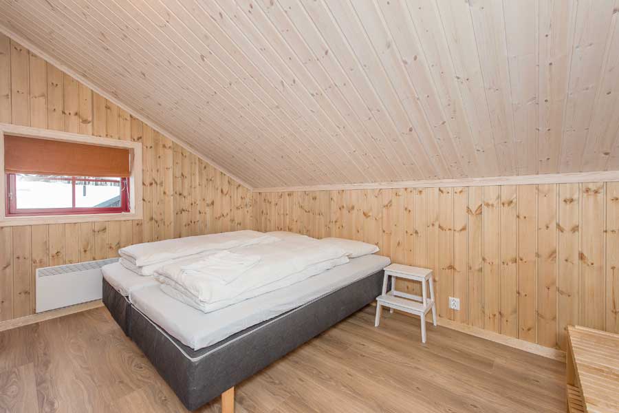 Slaapkamer met een tweepersoonsbed Rugdetunet appartementen