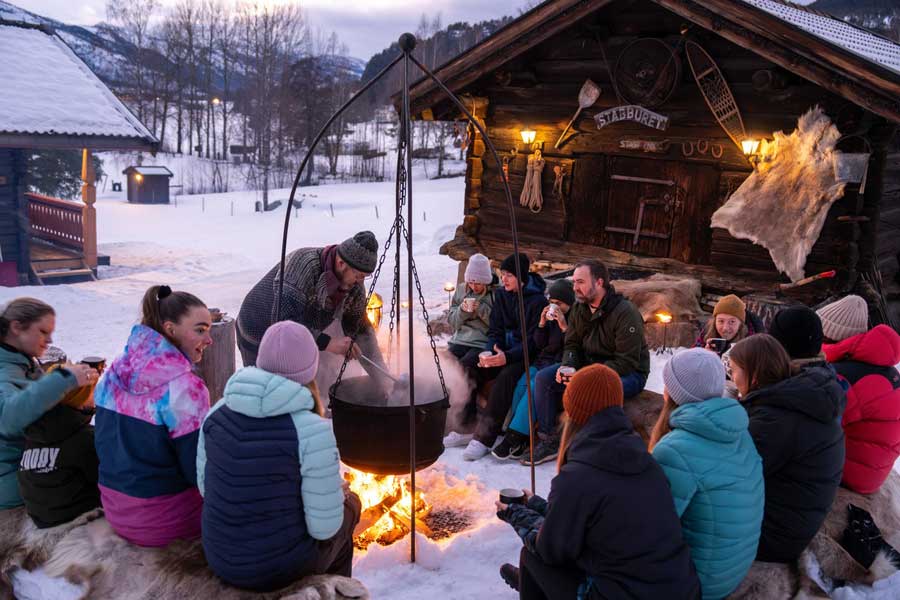 Mensen rondom het vuur bij de Trappers Cabin van Straand Hotel