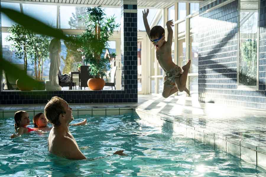 Gezin aan het zwemmen in zwembad van Straand Hotel