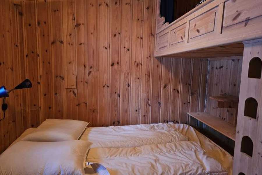 Slaapkamer met tweepersoonsbed en alkoof in hytta
