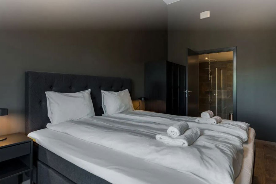 Slaapkamer met een tweepersoonsbed en badkamer in een appartement van Trysil Alpine Lodge
