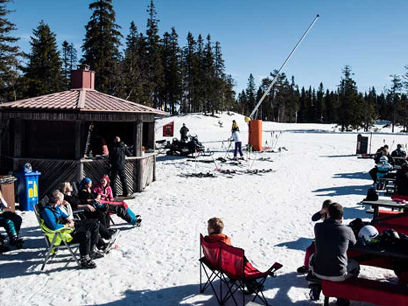 Skiërs genietend in de zon op de piste in Kläppen