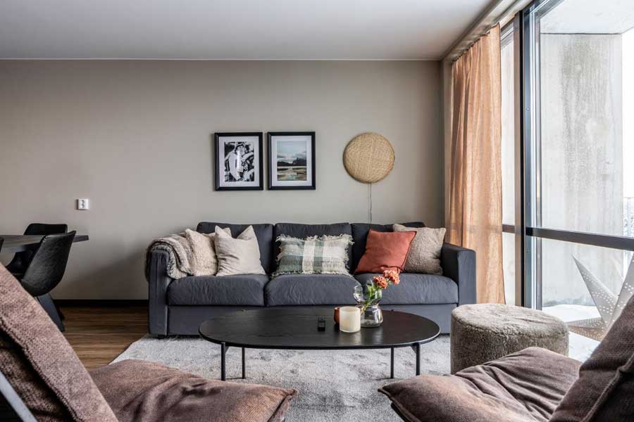 Woonkamer met zitbank en fauteuils in een appartement van Parkbyn