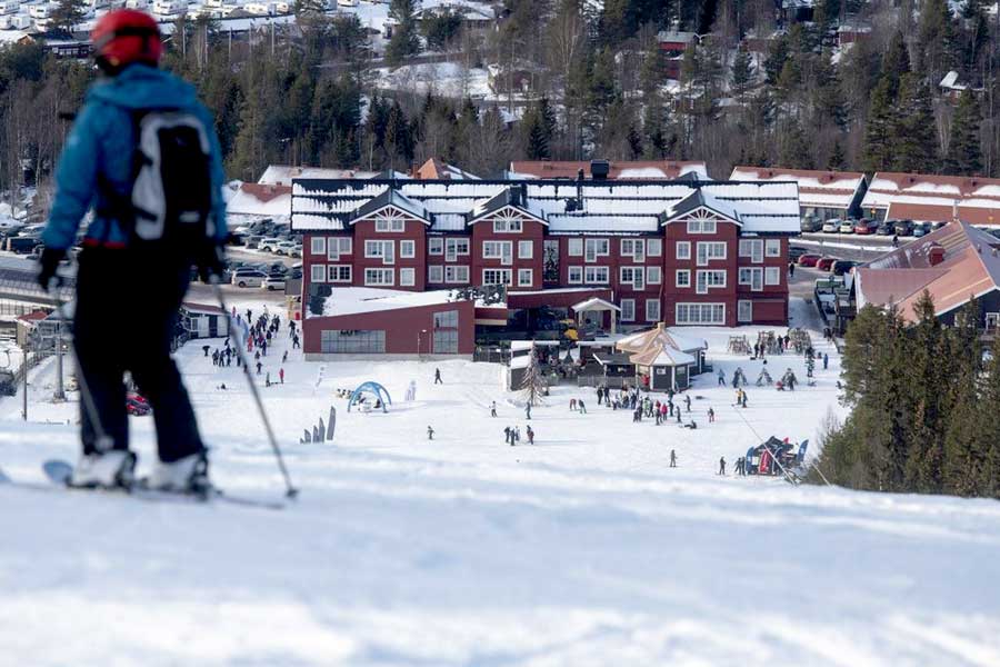 Skiërs in de sneeuw met Hotel Kurbits op de achtergrond
