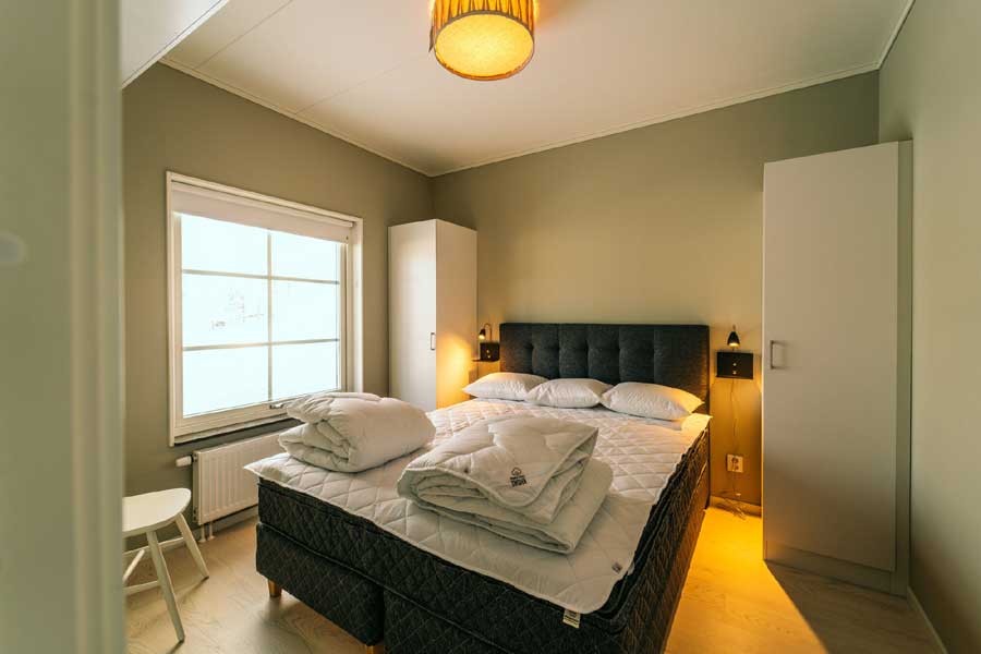 Slaapkamer met tweepersoonsbed in de Tranangårdarna appartementen, Kläppen