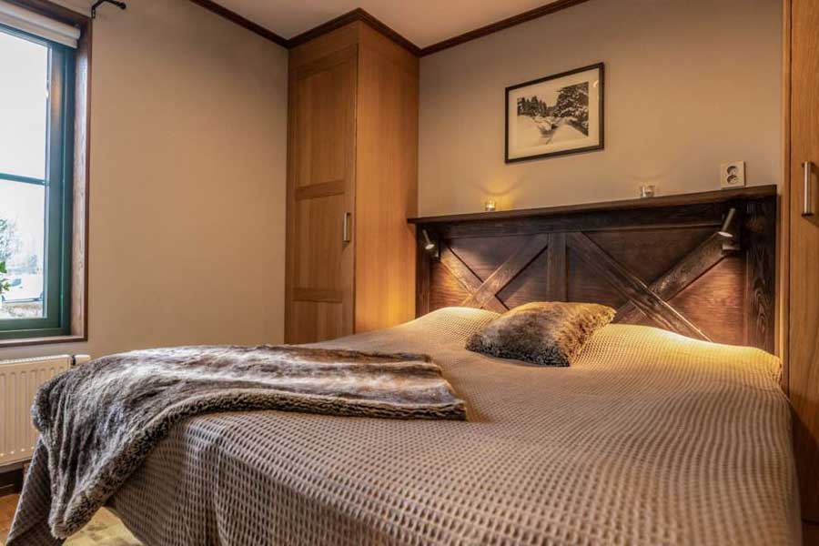 Slaapkamer met een tweepersoonsbed in een Ski Lodge Village appartement